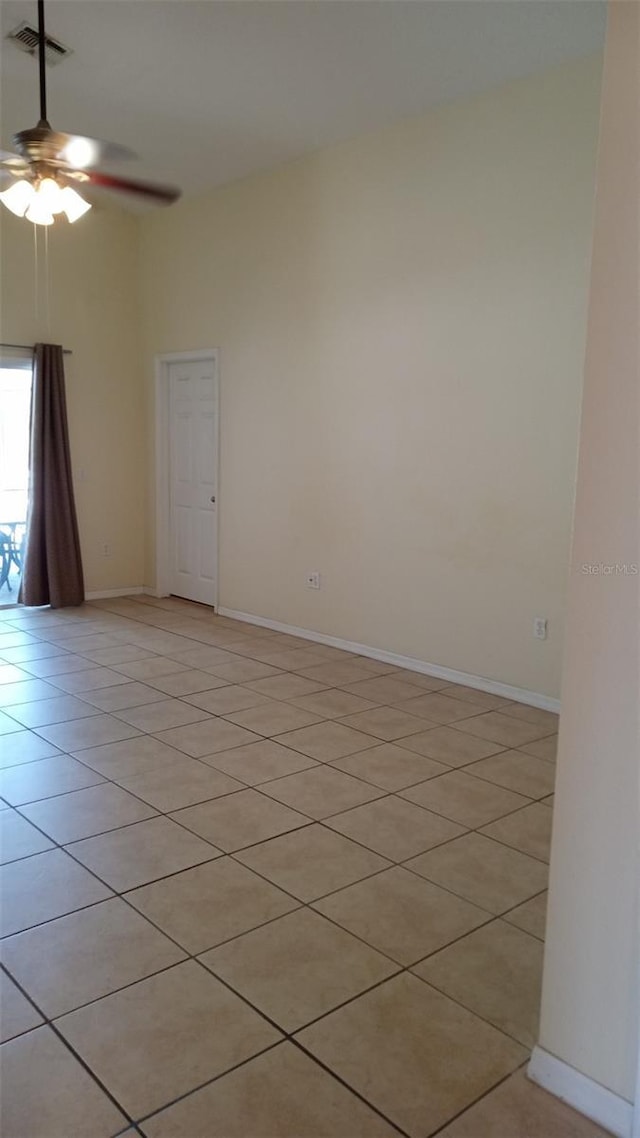unfurnished room featuring light tile patterned floors, visible vents, ceiling fan, and baseboards
