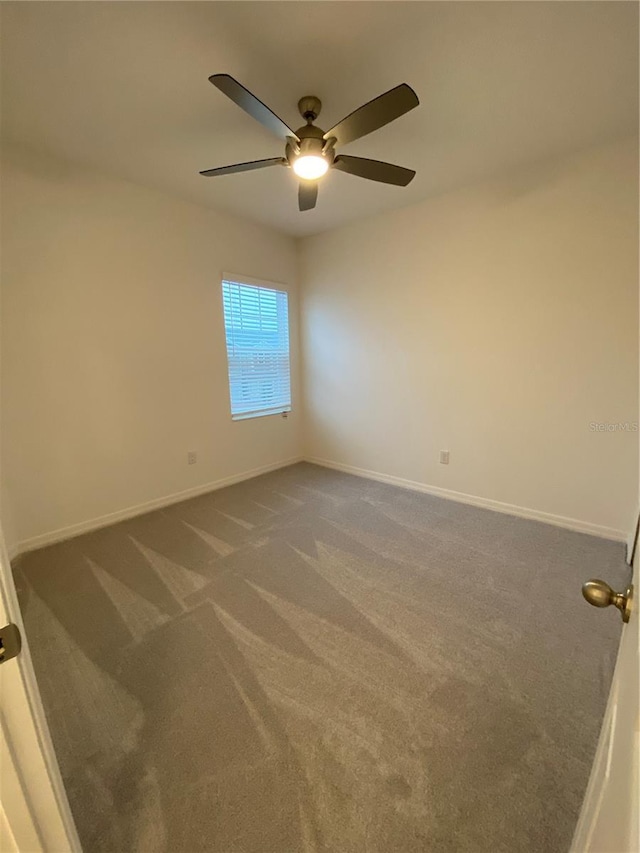 empty room with carpet flooring, baseboards, and a ceiling fan