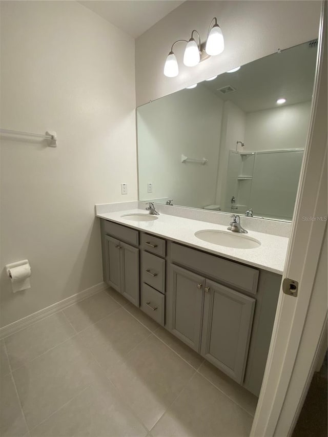 full bath featuring tile patterned floors, a shower, double vanity, and a sink