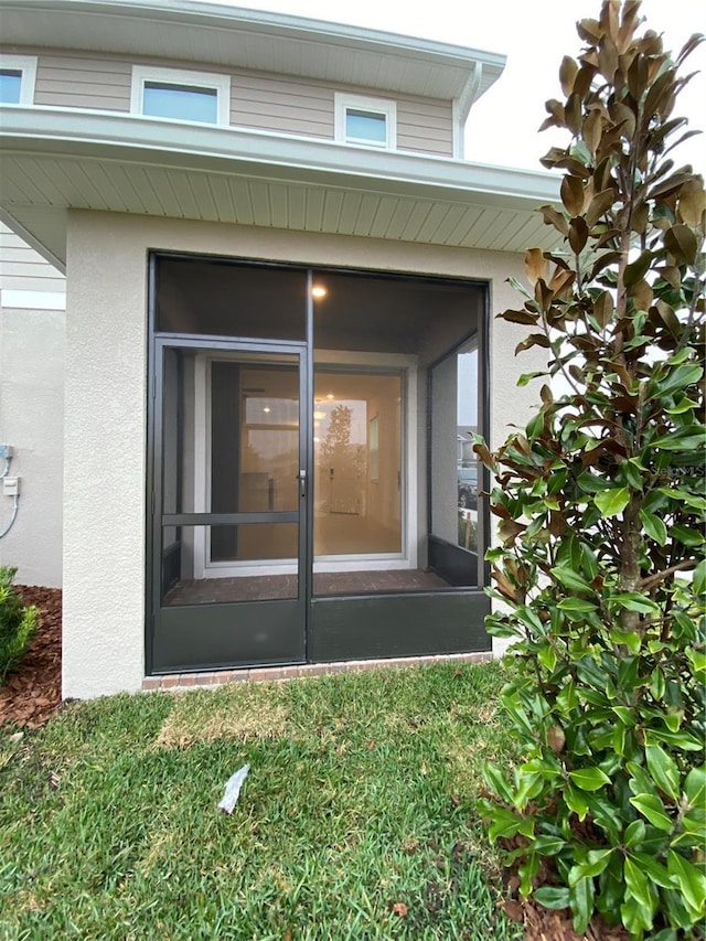 doorway to property featuring stucco siding