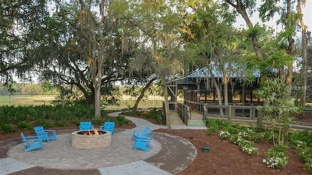 view of property's community featuring a deck, a fire pit, and a patio