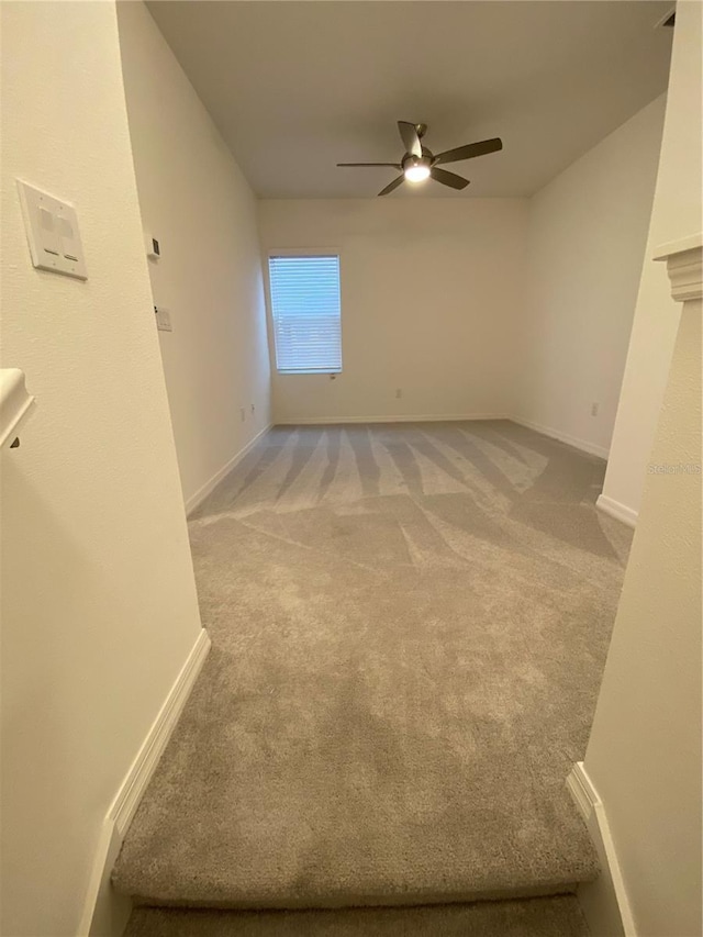 interior space with carpet flooring, baseboards, and a ceiling fan