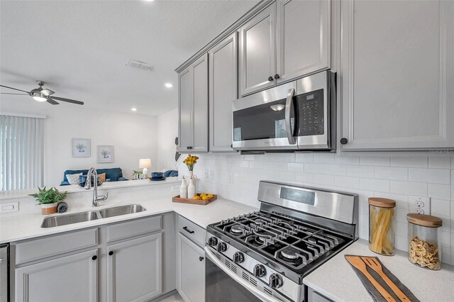 5728 Skytop Dr, Lithia, FL 33547 - kitchen featuring stainless steel appliances, a sink, gray cabinetry, and recessed lighting