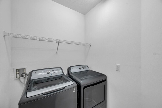 5728 Skytop Dr, Lithia, FL 33547 - washroom with washing machine and dryer and a textured ceiling