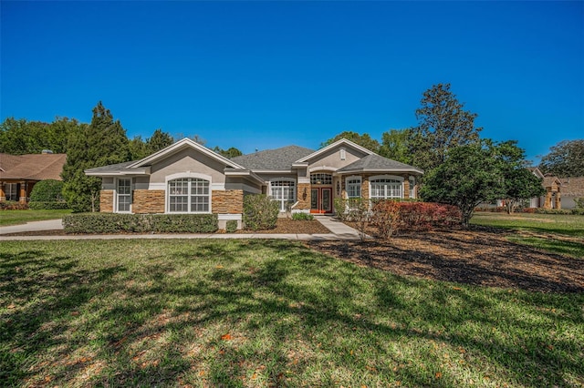 view of front of house with stucco siding, stone siding, and a front lawn