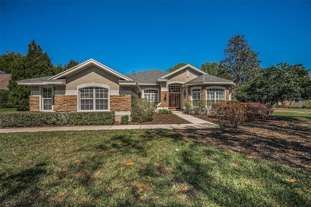 view of front of property featuring stucco siding, stone siding, and a front yard