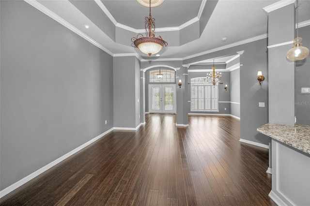 unfurnished dining area with dark wood-type flooring, a tray ceiling, french doors, baseboards, and a chandelier