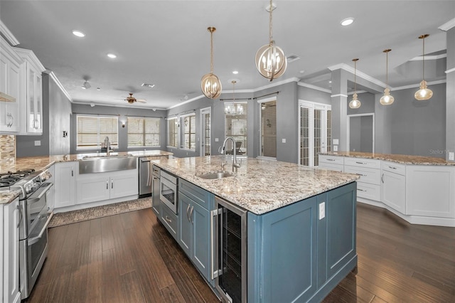 kitchen with wine cooler, an island with sink, appliances with stainless steel finishes, and a sink