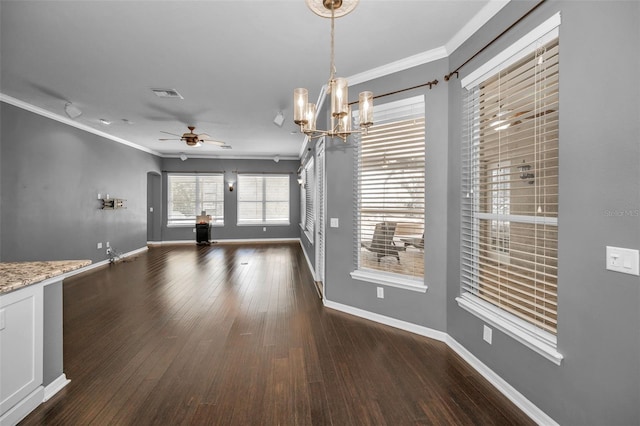 unfurnished dining area featuring visible vents, crown molding, baseboards, ceiling fan with notable chandelier, and wood finished floors