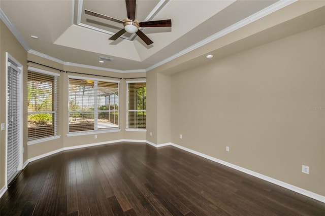 spare room with baseboards, dark wood-style flooring, ornamental molding, ceiling fan, and a raised ceiling