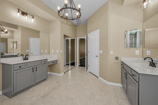 full bath featuring a chandelier, baseboards, and a sink