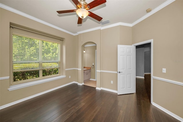 empty room with arched walkways, dark wood-style flooring, a ceiling fan, and crown molding