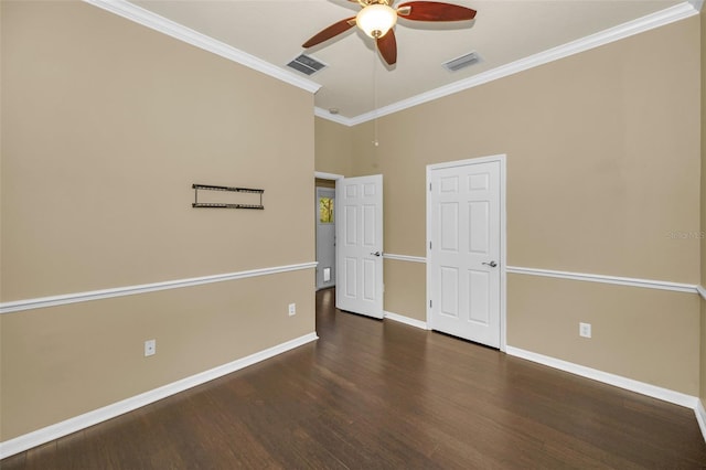 spare room with wood finished floors, baseboards, a ceiling fan, visible vents, and ornamental molding