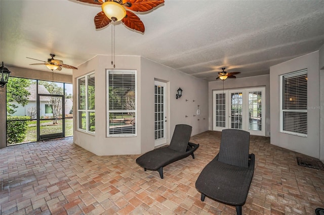 unfurnished sunroom with ceiling fan