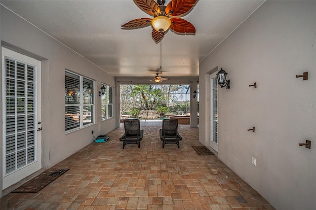 unfurnished sunroom featuring a ceiling fan