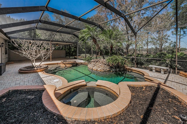 view of swimming pool featuring a patio, a lanai, and a pool with connected hot tub