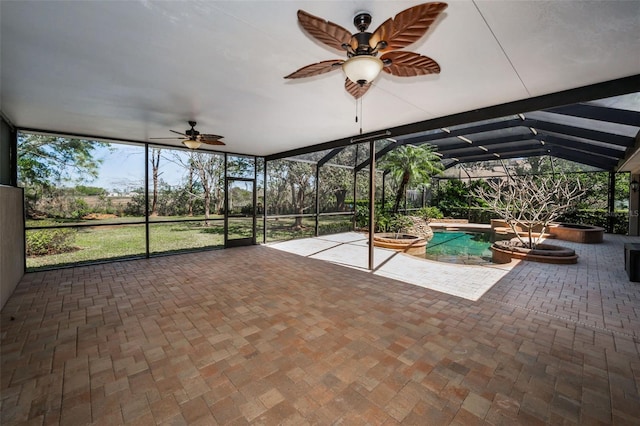 exterior space featuring a patio area, glass enclosure, an in ground hot tub, and a ceiling fan