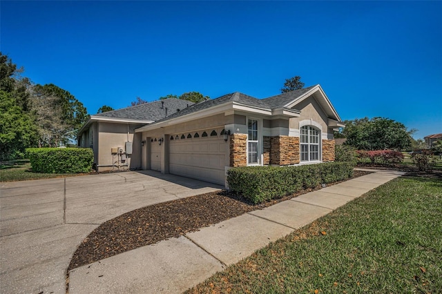 view of side of home with stucco siding, stone siding, driveway, and an attached garage