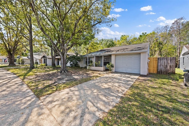 ranch-style home with a front lawn, fence, stucco siding, driveway, and an attached garage