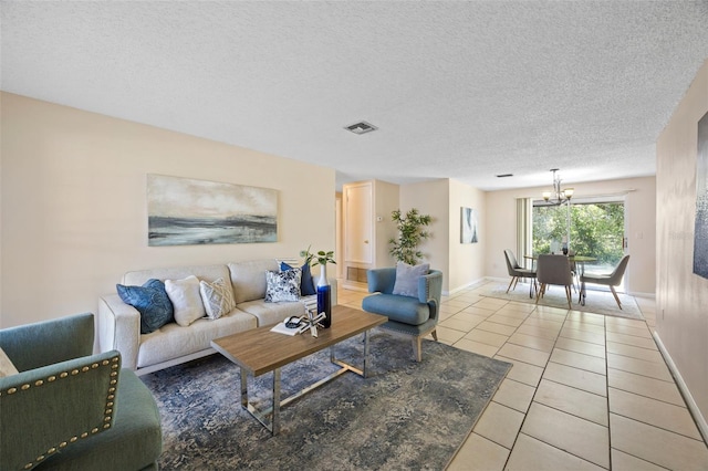 living room featuring a notable chandelier, visible vents, light tile patterned floors, and a textured ceiling