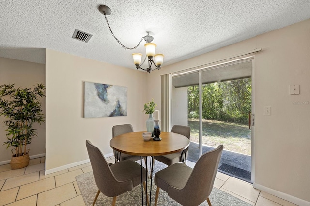 dining space with visible vents, baseboards, light tile patterned floors, a notable chandelier, and a textured ceiling