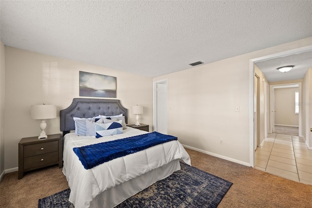 tiled bedroom featuring carpet flooring, baseboards, visible vents, and a textured ceiling