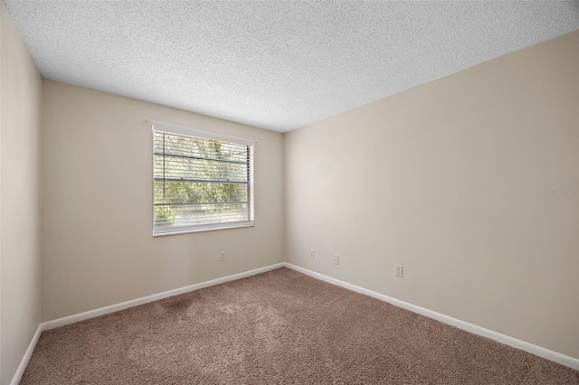 unfurnished room with a textured ceiling, baseboards, and carpet floors