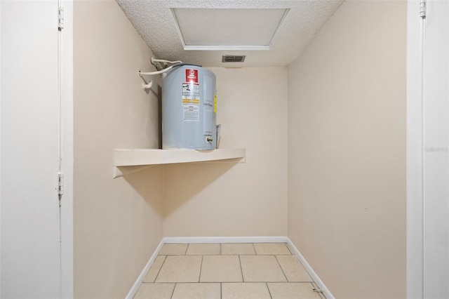 utility room featuring visible vents and electric water heater