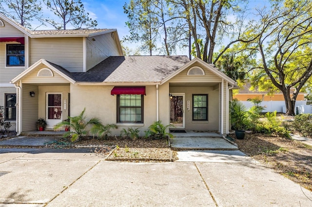 view of front of property with stucco siding and roof with shingles