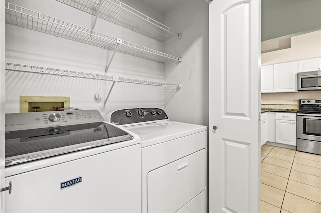 laundry room with light tile patterned flooring, laundry area, and washer and dryer