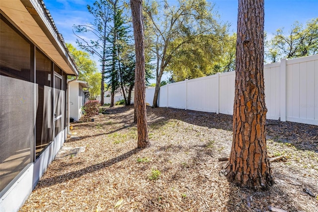 view of yard with a fenced backyard and a sunroom