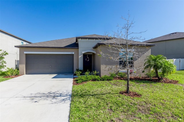 view of front of property with stucco siding, an attached garage, concrete driveway, and a front yard