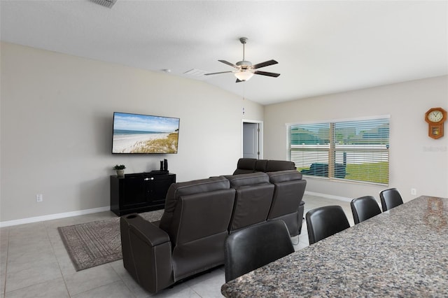 living room with light tile patterned floors, baseboards, lofted ceiling, and a ceiling fan