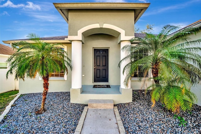 doorway to property featuring stucco siding