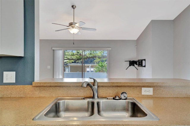 kitchen with lofted ceiling, light countertops, a ceiling fan, and a sink