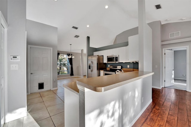 kitchen featuring visible vents, high vaulted ceiling, appliances with stainless steel finishes, and white cabinetry