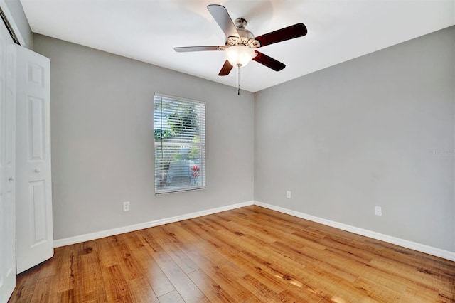 spare room featuring a ceiling fan, wood finished floors, and baseboards