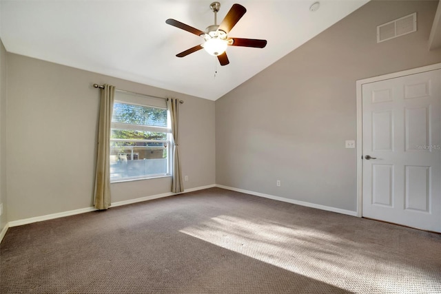 carpeted spare room with lofted ceiling, baseboards, visible vents, and ceiling fan