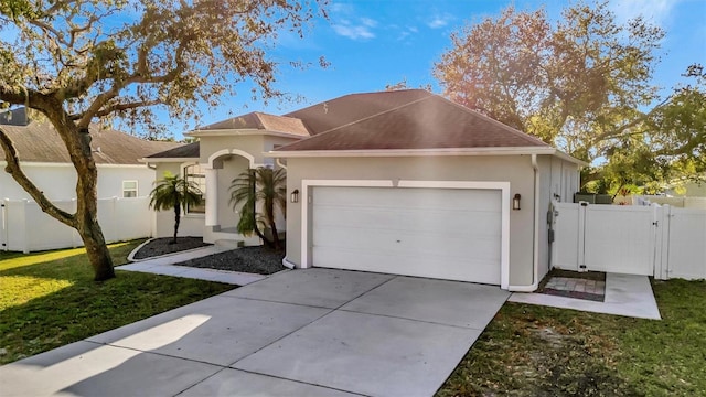 ranch-style home featuring concrete driveway, a gate, fence, and a garage