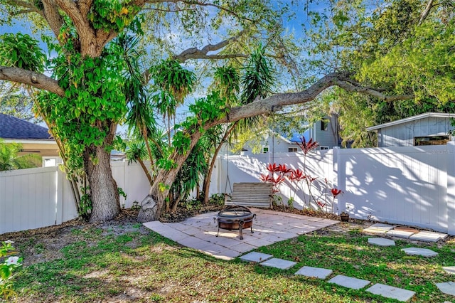 view of yard featuring a patio area, a fenced backyard, and an outdoor fire pit