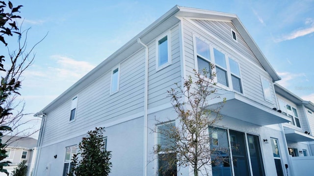 view of home's exterior with stucco siding and fence