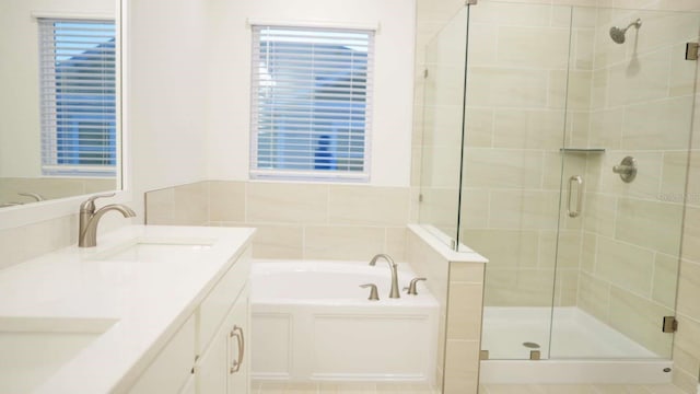 full bath featuring a bath, a shower stall, double vanity, and a sink