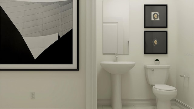 bathroom with toilet and baseboards