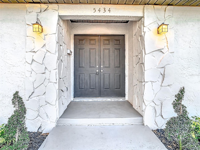 view of exterior entry featuring stucco siding