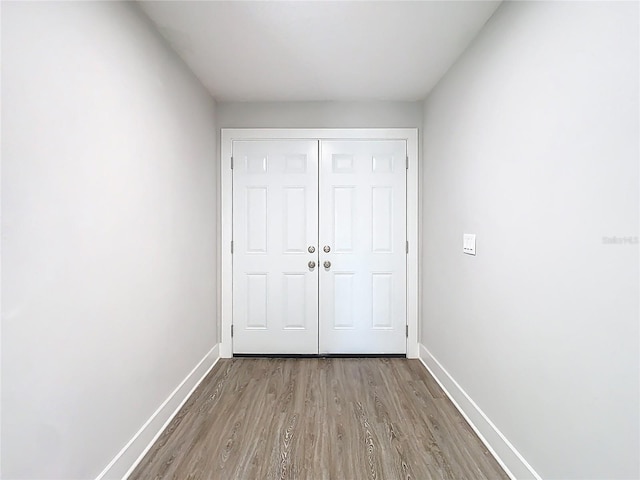 unfurnished bedroom with a closet, baseboards, and wood finished floors