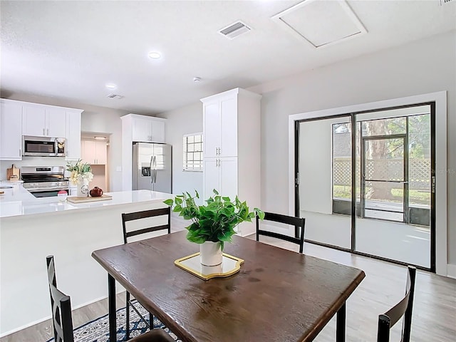 dining area featuring recessed lighting, visible vents, attic access, and light wood finished floors