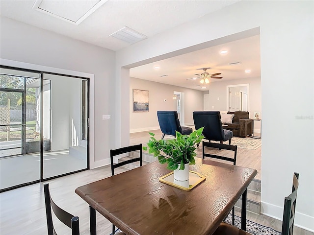 dining space with visible vents, light wood-style flooring, a ceiling fan, and baseboards