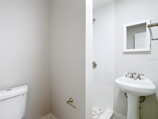 bathroom featuring toilet and a tile shower