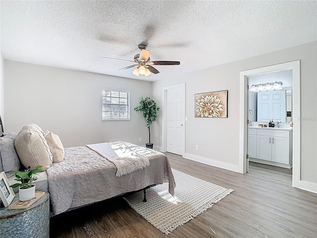 bedroom with baseboards, a textured ceiling, and light wood finished floors