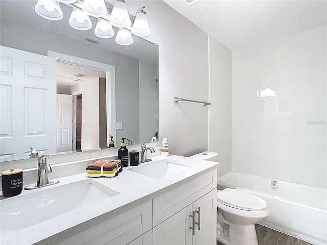 bathroom featuring a sink, visible vents, toilet, and double vanity